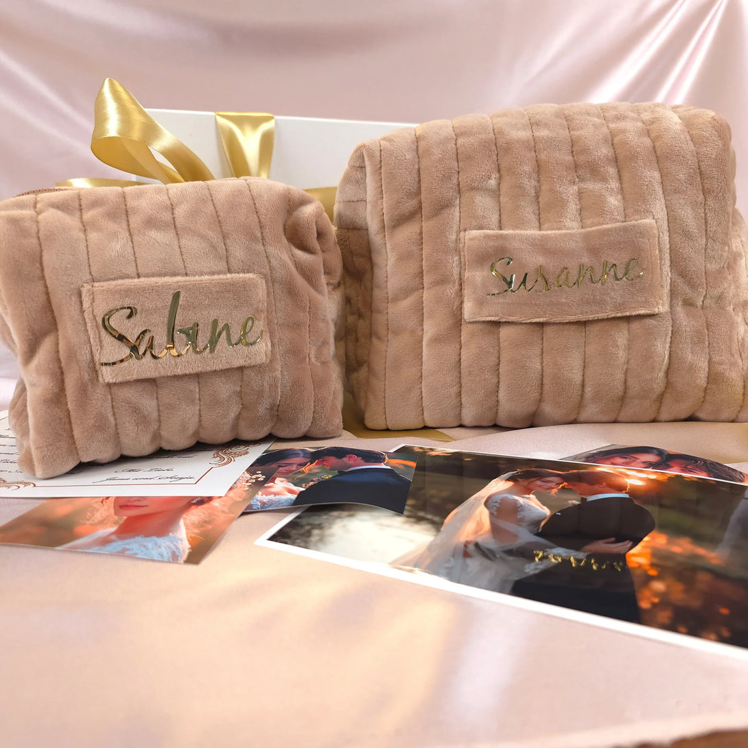 Two personalized soft beige leather pouches with names on them, displayed with wedding photos